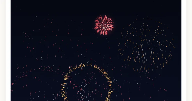 みんなで花火大会の画面: 夜空に赤と橙の花火が開いている
